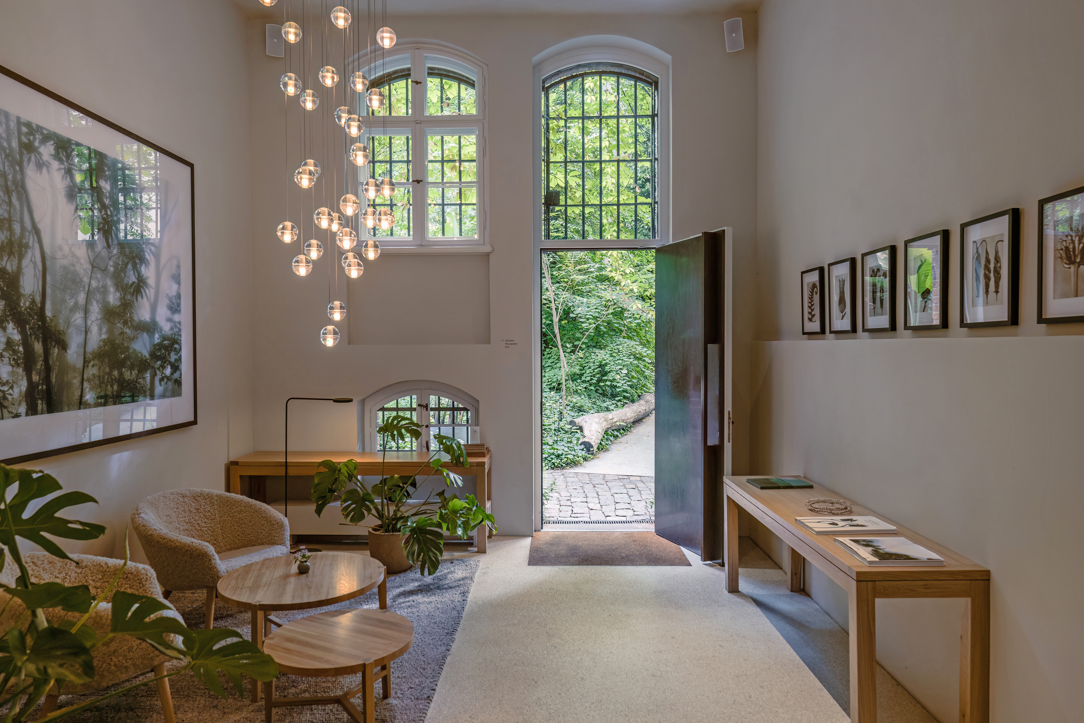 Historic architecture meets a restrained interior: the garden lobby at Wilmina in Berlin-Charlottenburg opens directly onto the greenery. The property was named “Hotel of the Year” at the Independent Hotel Show Munich Awards 2026. Photo: © Wilmina