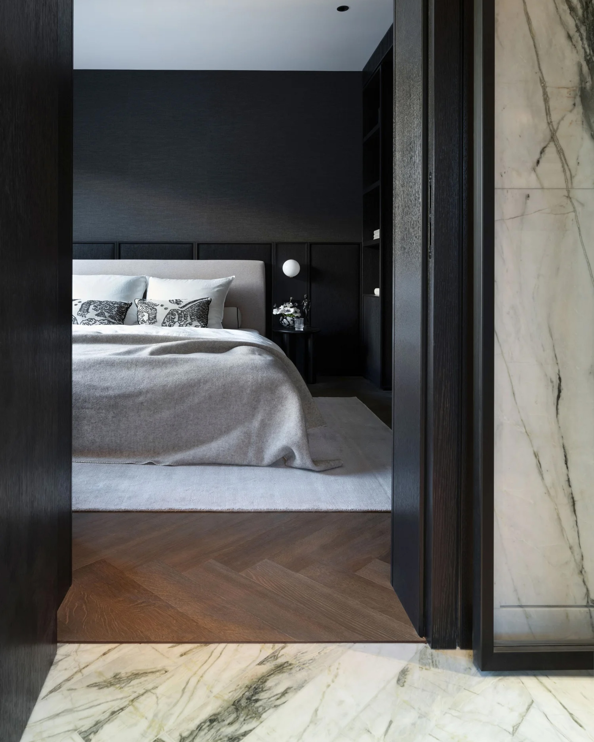 A quiet retreat: bedroom with dark built-ins, natural stone, and a restrained color palette.