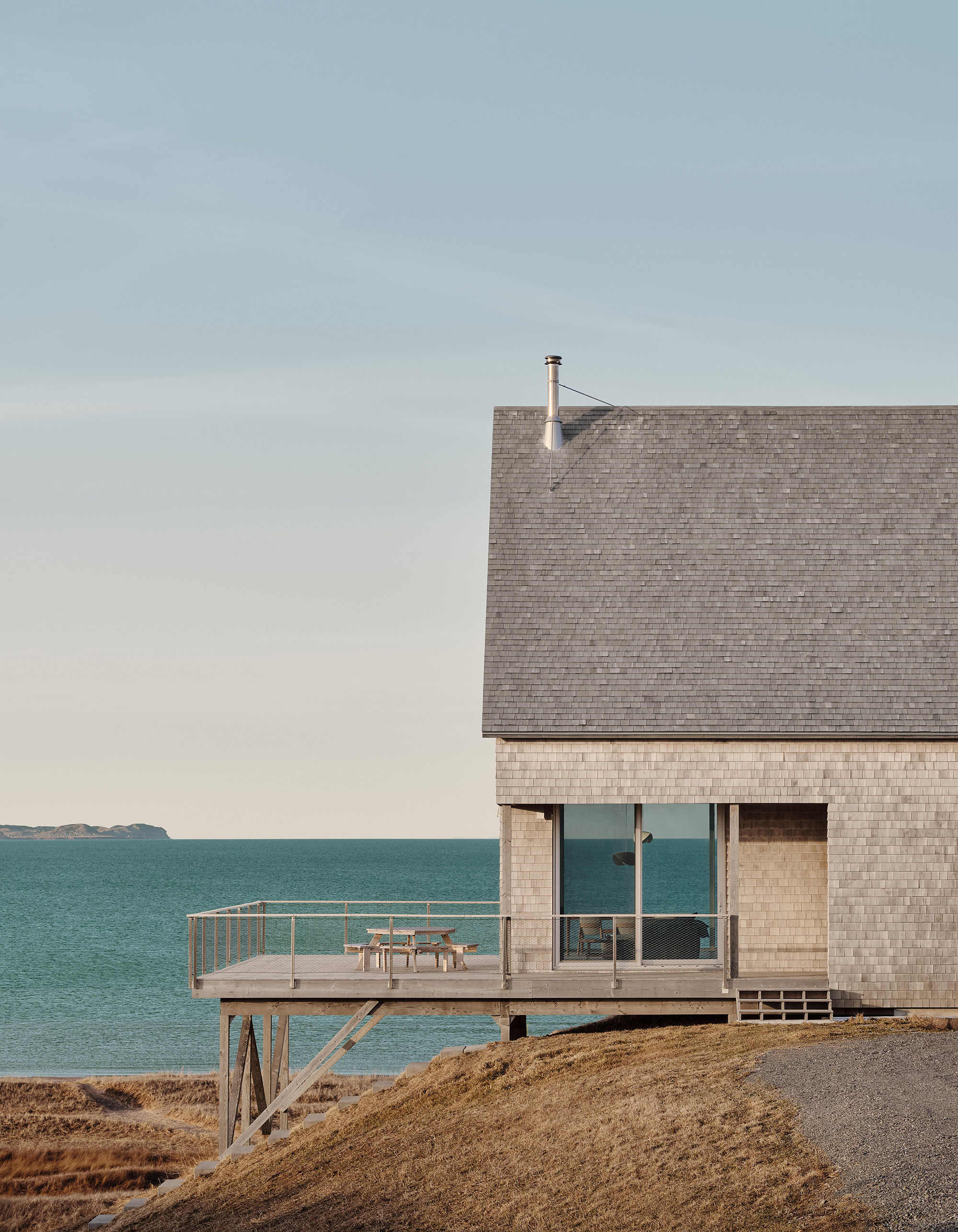 The large terrace extends over the slope on timber piles. This preserves direct sea views while reducing disturbance to the soil and existing vegetation