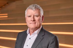 Zumtobel Group CEO Alfred Felder in a dark suit against horizontal orange light lines.