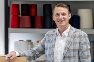 Gabriel CEO Anders Hedegaard Petersen standing in front of yarn samples in a showroom.
