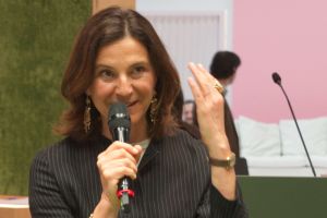 Giovanna Vitelli speaking into a microphone at a design and contract event.